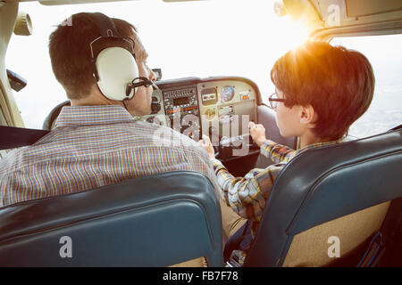 Vue arrière du père et fils dans le cockpit de l'avion privé Banque D'Images