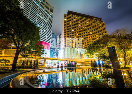 Gratte-ciel et une fontaine au parc Victoria de nuit, à Causeway Bay, Hong Kong, Hong Kong. Banque D'Images