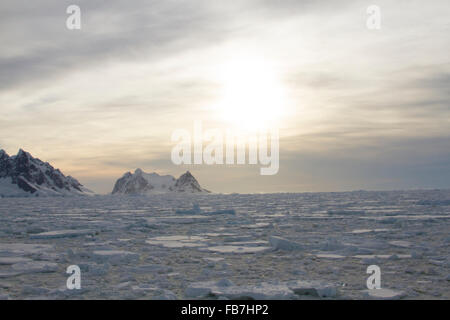 Coucher du soleil sur le champ de glace à l'entrée du Canal Lemaire, de l'Antarctique en été. Banque D'Images