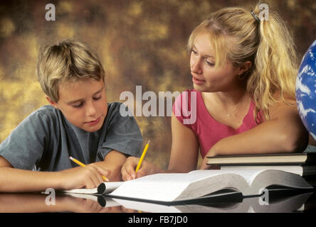 Grande sœur aider jeune frère étude Banque D'Images