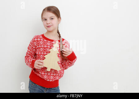 Smiley kid portant beau chandail rouge et holding Christmas decoration Banque D'Images