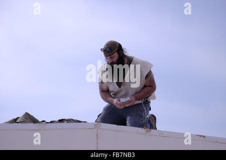 Israël, Cisjordanie. 11 janvier, 2016. Un colon juif répare le toit de sa maison à Esh Kodesh qui est un petit établissement situé à l'avant-poste israélien à l'extérieur des limites de sa maison mère juive de peuplement Shilo près du village palestinien de Qusra, en Cisjordanie, Israël le 11 janvier 2016 Le Shiloh Valley abrite une chaîne de colonies de peuplement illégales, il y a un permanent de règlement des différends entre l'ESH Kodesh colons et Palestiniens à proximité village Qusra sur la propriété des terres. Credit : Eddie Gerald/Alamy Live News Banque D'Images