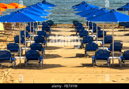 Transats dans une plage de sable de Réthymnon, en Crète, Grèce, Méditerranée. Banque D'Images