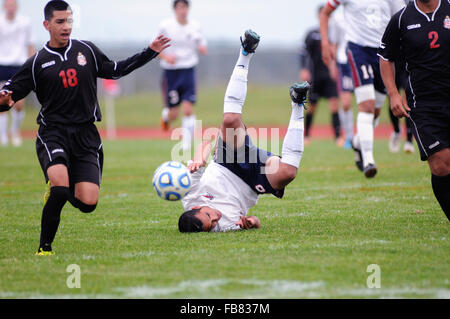 Dvd les vents jusqu'à l'envers sur le gazon après avoir été détenus par un adversaire qui a donné lieu à un coup franc lors d'un match de l'école secondaire. USA. Banque D'Images