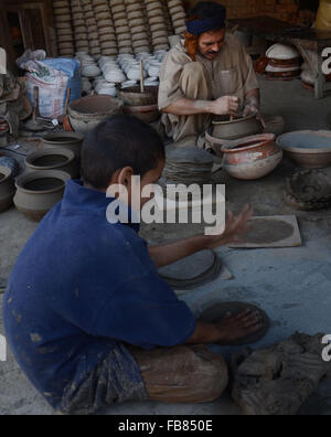 Lahore, Pakistan. 12 Jan, 2016. Les travailleurs pakistanais occupés en préparation de l'argile pour faire des pots en argile traditionnelles différentes. La poterie est la plus ancienne du Pakistan l'artisanat. Au début les hommes et les femmes ont découvert que durcir la poterie moulée en forme de cendres chaudes des contenants solides pour transporter et stocker les denrées alimentaires. © Rana Sajid Hussain/Pacific Press Agency/Alamy Live News Banque D'Images