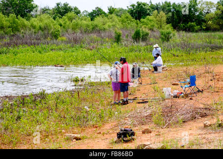 Les gens pêchent dans les eaux montantes du lac Hefner à Oklahoma City, Oklahoma, États-Unis, après une pluie printanière. Banque D'Images