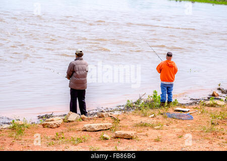 Deux hommes poissons dans la montée des eaux du lac Hefner à Oklahoma City après une pluie de printemps. New York, USA. Banque D'Images