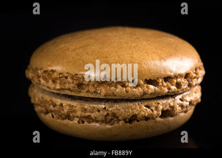 Un macaron au chocolat sur fond noir Banque D'Images