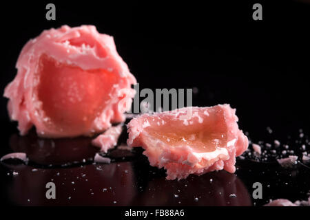 De délicieux bonbons rouge broken rempli d'alcool sur fond noir Banque D'Images