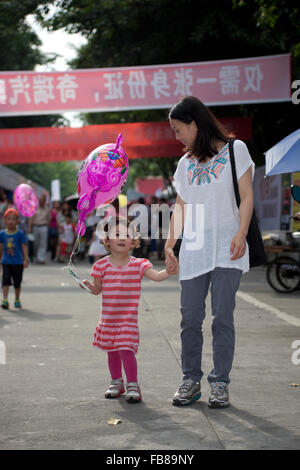 Un enfant de race mixte et sa mère chinoise lors d'un salon dans une ville en Chine. Banque D'Images