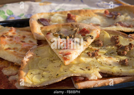 Variété de pizzas faites maison coupé en petits morceaux Banque D'Images