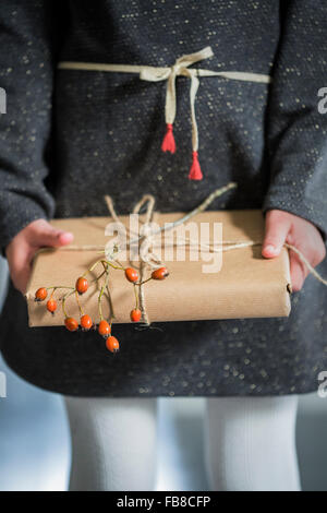 La Suède, Girl (6-7) holding wrapped Christmas present