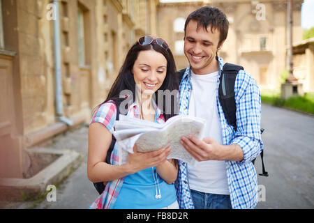 Heureux couple de touristes en vacances vous cherchez une rue dans une carte. Banque D'Images