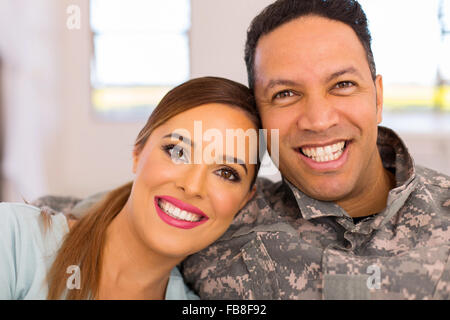 Belle armée couple sitting on sofa at home Banque D'Images