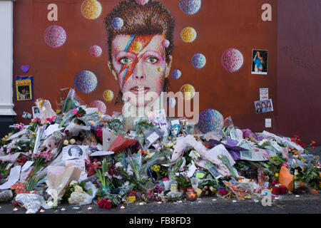 12 janvier 2016 Londres : les amateurs de musique anglaise emblématique artiste David Bowie qui est mort du cancer à l'âge de 69 ans le dimanche 10 janvier, se réunir pour rendre hommage à un sanctuaire de fortune de fleurs et des hommages à la garçon de Brixton, dans le sud de Londres. Les banlieusards arrêté par avant d'entrer dans la station de métro voisine pour prendre des photos et silencieusement se souvenir de leurs héros grands jours jouant les musiques de leur enfance. Richard Baker / Alamy Live News. Banque D'Images