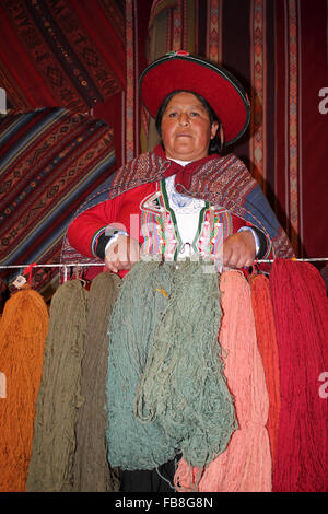 Habillé traditionnellement femme péruvienne Holding teints naturellement fil de laine de lama et d'alpaga Banque D'Images