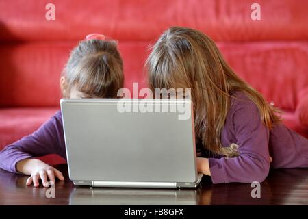 Deux jeunes filles jouent avec un ordinateur, l'Allemagne, ville d'Osterode, 08. Janvier 2016. Photo : Frank May Banque D'Images