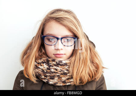 Closeup portrait of beautiful blond Caucasian teenage girl à lunettes et écharpe over white wall background Banque D'Images