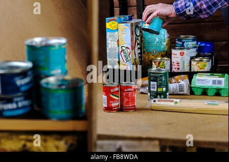 Emballage bénévoles un plateau de nourriture dans une banque alimentaire. Banque D'Images