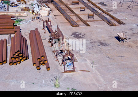 La pipe du fer éclairée par le pieu et d'autres équipements industriels en plein air . Lieu de travail de construction Banque D'Images