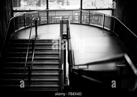 Escalier en noir et blanc et de l'atterrissage dans la station de métro de Londres à la lumière naturelle. Un contraste élevé Moody s'escaliers Banque D'Images