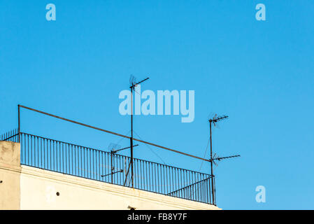 Quatre antennes sur un toit contre le ciel Banque D'Images