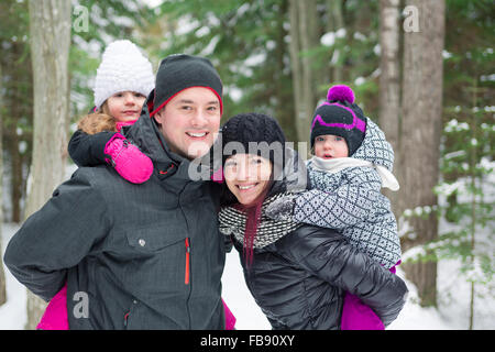 Heureux balades familiales et en jouant avec la neige en forêt d'hiver Banque D'Images