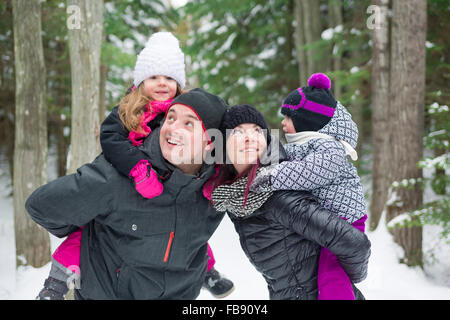 Heureux balades familiales et en jouant avec la neige en forêt d'hiver Banque D'Images