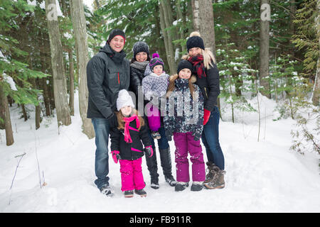 Heureux balades familiales et en jouant avec la neige en forêt d'hiver Banque D'Images