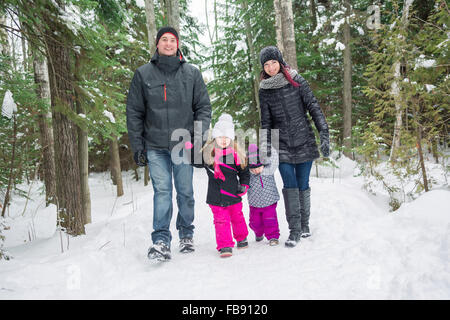 Heureux balades familiales et en jouant avec la neige en forêt d'hiver Banque D'Images