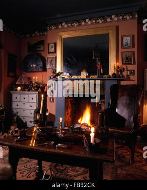 Miroir au-dessus de cheminée dans un style victorien sombre salon avec une chaise en bois style crofters à Banque D'Images