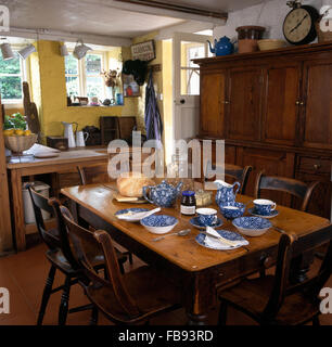 Blanc +bleu Calico 'thé' sur l'ancien jeu de table en bois pour le petit-déjeuner dans la cuisine cottage Banque D'Images