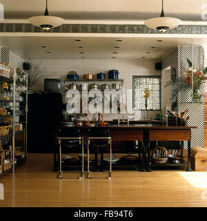 Tabourets en cuir Chrome +petit-déjeuner au bar en 1990 Cuisine équipée d''un parquet et d'un faux plafond avec des briques de verre Banque D'Images