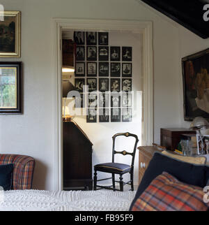 Collection de photographies noir +blanc sur mur à travers la porte de chambre blanche Banque D'Images