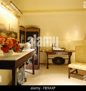 Vase de roses rouges sur la table console dans années 80, hall avec des bougies allumées sur une table Banque D'Images