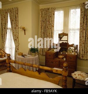 Des rideaux sur la fenêtre au-dessus d'une coiffeuse en pin chambre 80 Banque D'Images