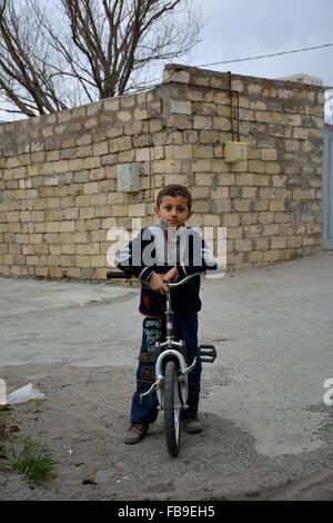 BAKU, AZERBAÏDJAN - le 14 novembre 2013 Jeune homme à vélo dans le unmodernized au nord de Bakou Banque D'Images