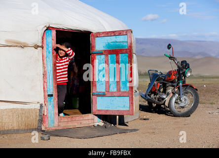 Une fille se moque de sa tête hors de sa famille ger tente dans le Tsaast Uul Valley dans l'ouest de la Mongolie. Banque D'Images