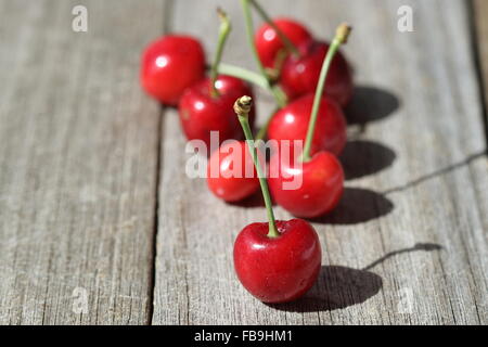 Close up de Prunus avium cerises ou connu sous le nom de Lapin cerises sur planche de bois Banque D'Images