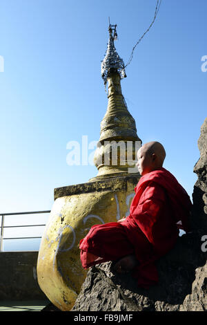 Un jeune moine assis sur le sommet du Mt. Popa au Myanmar. Banque D'Images