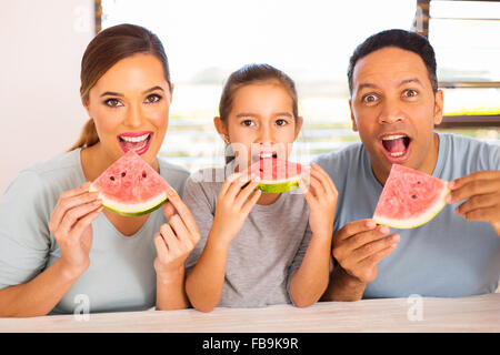 Belle famille de trois eating watermelon Banque D'Images