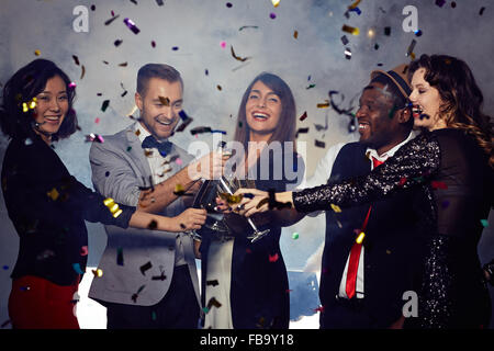 Cheerful friends toasting with champagne at New Year's Eve party Banque D'Images