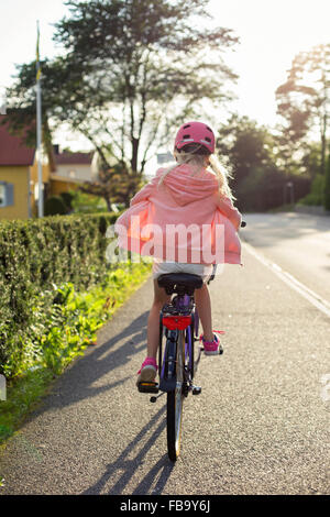 La Suède, Vastergotland, Lerum, Girl (10-11) wearing pink Casque vélo le long street Banque D'Images