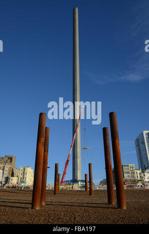 À côté du reste de la jetée Ouest une grue soulève les dernières sections de l'observation de l'pod je BA360 au cours de la construction des tours d'observation sur la plage de Brighton, East Sussex, Angleterre. Banque D'Images