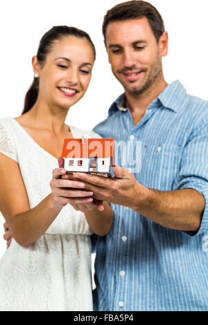 Young couple holding model house Banque D'Images