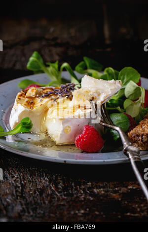 Fromage de chèvre cuite au miel et framboises Banque D'Images