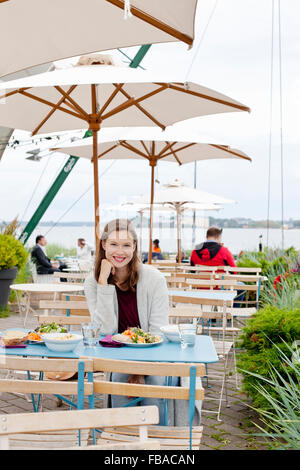 La Finlande, Helsinki, Uusimaa, Kaivopuisto, Portrait of smiling young woman in restaurant en plein air Banque D'Images