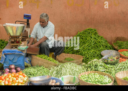 L'homme indien vendant des légumes frais au marché du vendredi, dans le quartier animé de Mapusa, Mapusa, Nord de Goa, Inde Banque D'Images