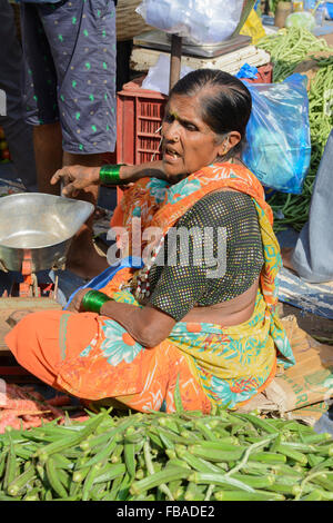 Femme indienne la vente de légumes frais à Mapusa, dans le quartier animé de vendredi, marché, Nord de Goa Anjuna, Inde Banque D'Images