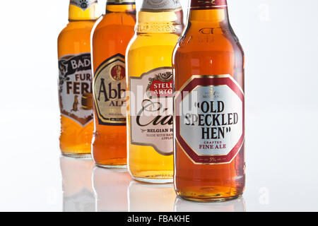 Quatre bouteilles de bière et de cidre colorées disposées pour montrer la profondeur de champ et mettre l'accent sur la marque Banque D'Images